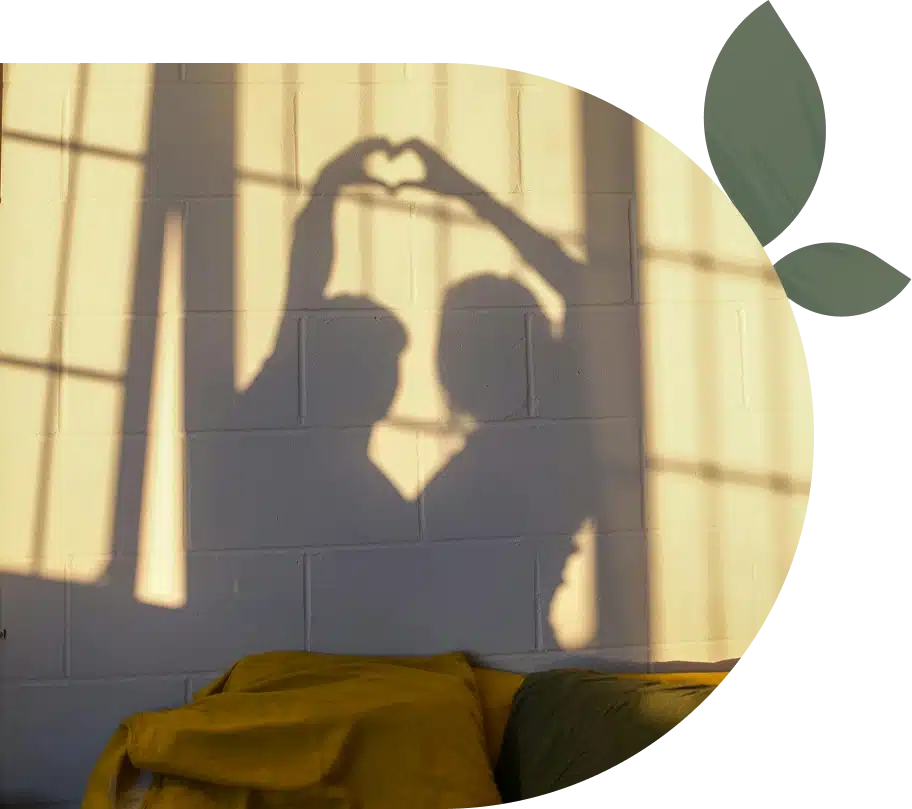 Couple's shadow forming a heart on sunlit wall