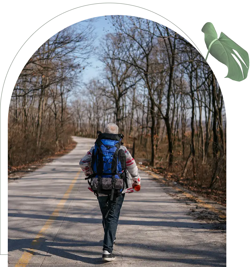 A person with a backpack walking on a road.