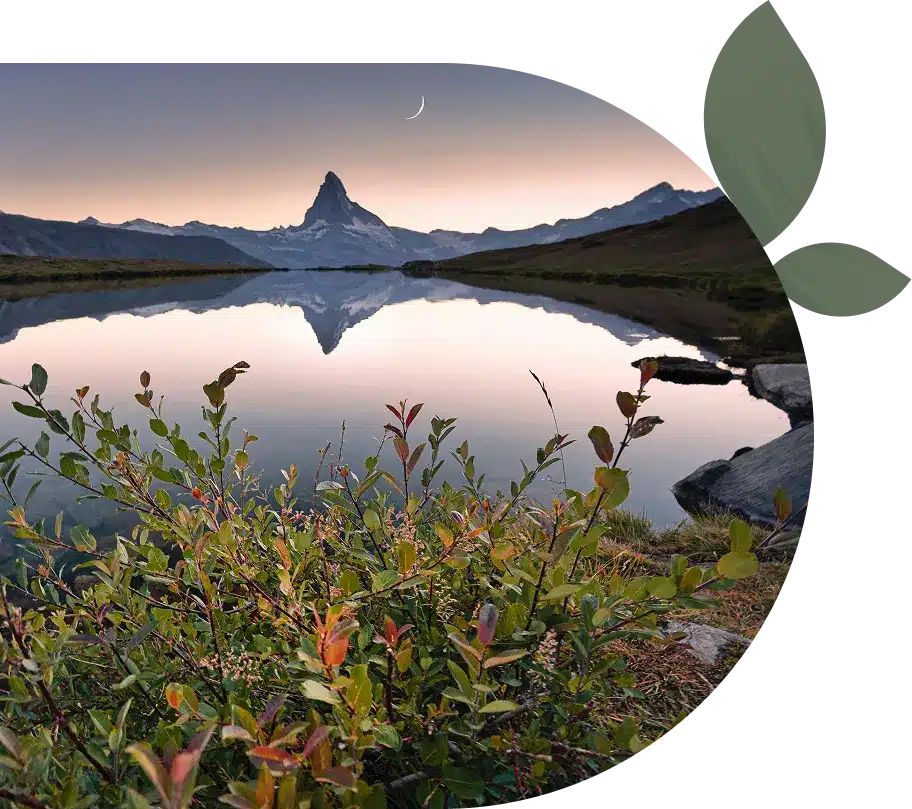 A lake reflecting a mountain and the moon.